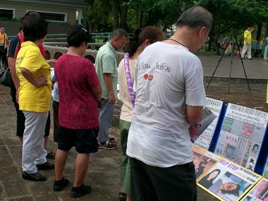 路人仔细阅读法轮功真相展板