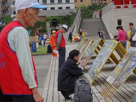 真相展板前一直有各地的游客观看