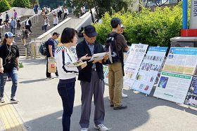 市民们通过真相图片展板在了解法轮功真相