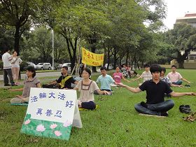 '星期日下午，青年学子在兴大校园里炼法轮功。一旁走道上学员正在为民众做介绍。'