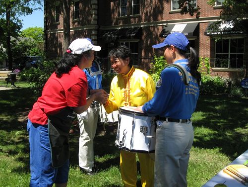 菲律宾裔义工Marie抓住腰鼓队成员付女士的手说：“你们一定要把这个传统的东西在世界弘扬。”