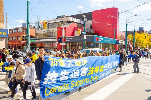 图1-9:二零一五年十月十日中午，多伦多法轮功学员在市中心举行今年诉江以来的第二次诉江大游行，所到之处引起民众的关注，很多民众表示支持并在制止活摘的请愿信上签名。