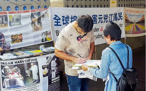 图4-7：法轮功学员在澳洲悉尼最繁华的商务中心之一帕拉马塔市（Parramatta）展示真相横幅，民众签名支持反迫害