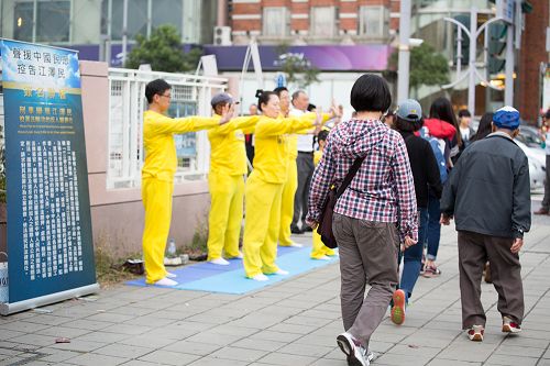 图2：法轮功学员向民众展示法轮功祥和优美的五套功法。