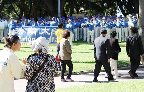 中国大陆华人游客被天国乐团的音乐吸引驻足观看