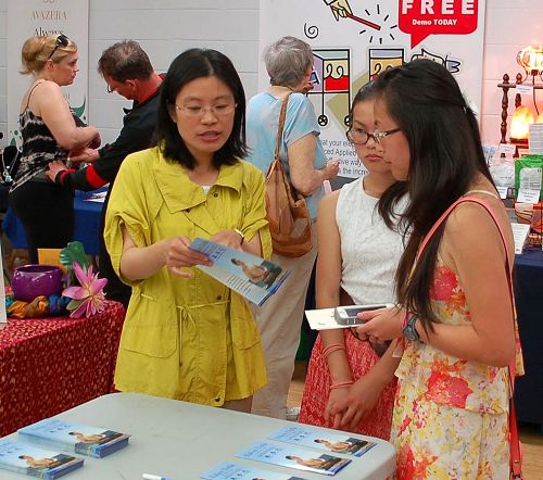 图3：素食节同时在室内和室外进行。图为法轮功学员在室内设立了真相展位，民众正在了解真相。