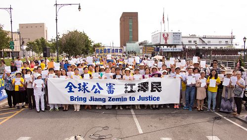 图1：多位纽约法轮功学员展示自己控告迫害元凶江泽民的诉状。