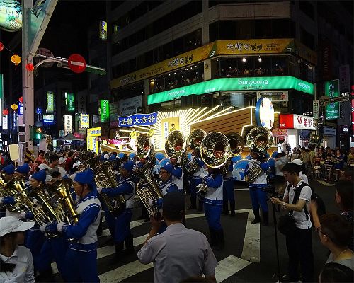 '图：法轮功学员组成的天国乐团、花车、仙女队与腰鼓队所组成的队伍，所到之处收到人们欢迎'