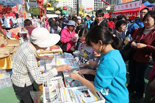 '图：法轮功学员在维园年宵市场开设的真相摊位，大受民众欢迎。'