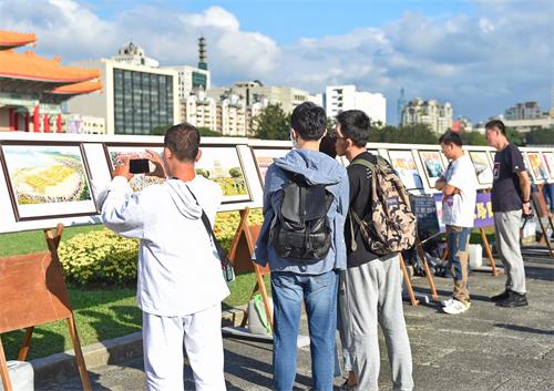 图4～5：游客站在真相展版前了解法轮功弘传世界与被迫害真相。