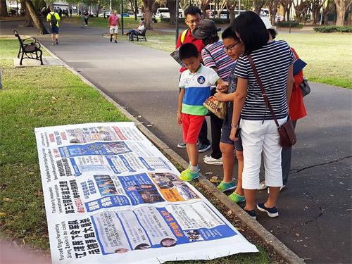 '图6：从中国来旅游的一家人一起看真相展板并一起退出中共组织'