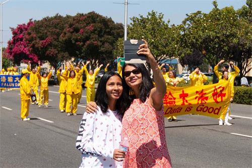 '图5：祥和的法轮功队伍吸引民众拍照留念'