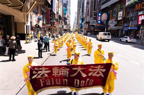 '图11～25：二零一九年五月十六日，万名不同族裔的法轮功学员在纽约曼哈顿中城42街上游行庆祝法轮大法弘传二十七周年，告诉世人“法轮大法好”。'