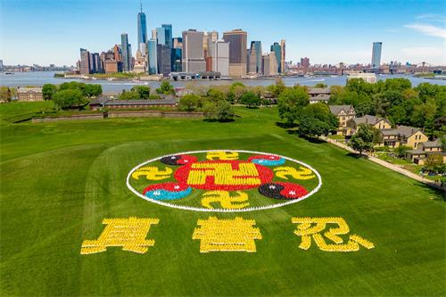 '图1：二零一九年五月十八日，五千法轮功学员在纽约总督岛公园（Governor’s Island），排出大型法轮图形和“真、善、忍”三字。'