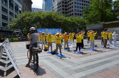 '图1～2：二零一九年七月十三日，在“七二零”反迫害二十年之际，西雅图法轮功学员在市中心的西湖公园（Westlake Park）举行集会，向过往民众传播真相'