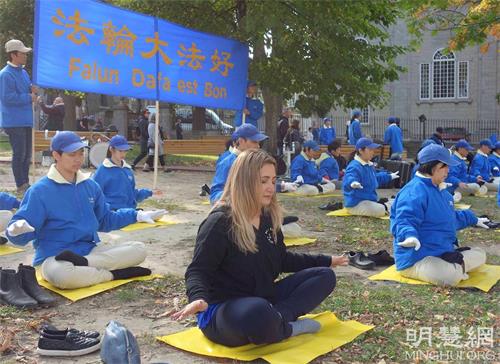 '图10：蒙特利尔学生艾里芙（Elif，中）初次次尝试法轮功功法，感觉到很强的能量。'