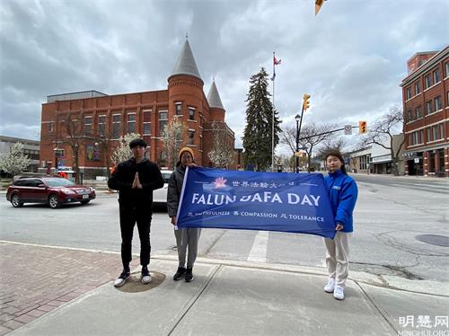 '图13：安省奥里利亚（Orillia）升旗庆祝世界法轮大法日，法轮功学员合影留念。'