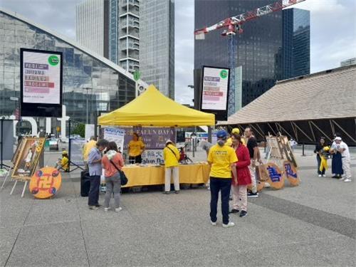 图1：法轮功学员在巴黎郊区拉德芳斯（La Défense）广场举行集会活动，向游人和民众展示法轮功功法，揭露中共迫害法轮功罪行。